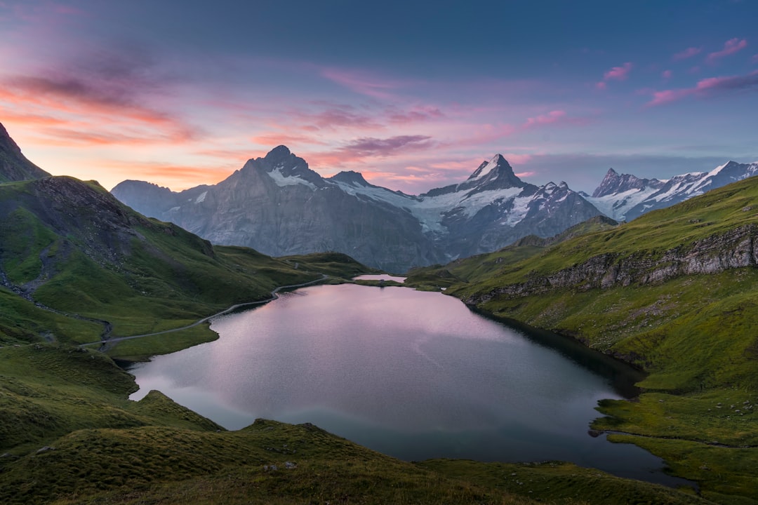 A mountain lake surrounded by green hills at sunrise