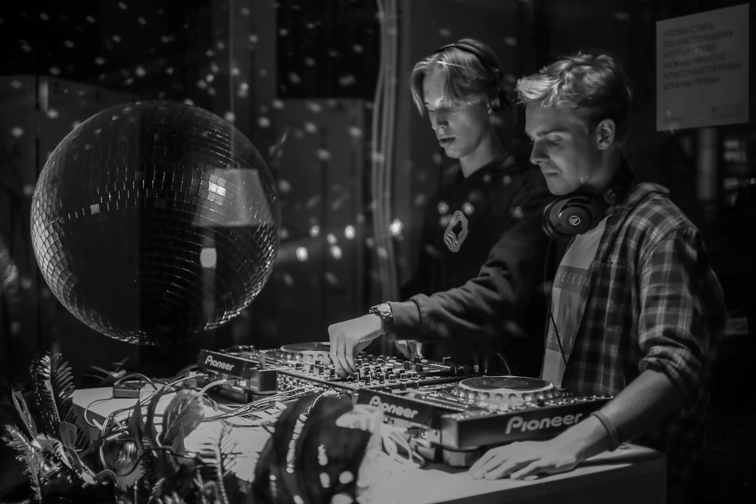a couple of men standing next to each other in front of a mirror