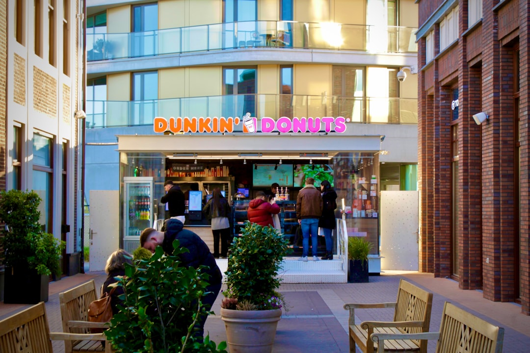 A dunkin' donuts shop in an urban setting.