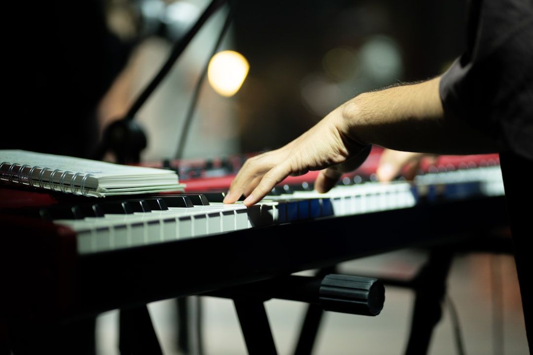 Musician playing a red electronic keyboard on stage
