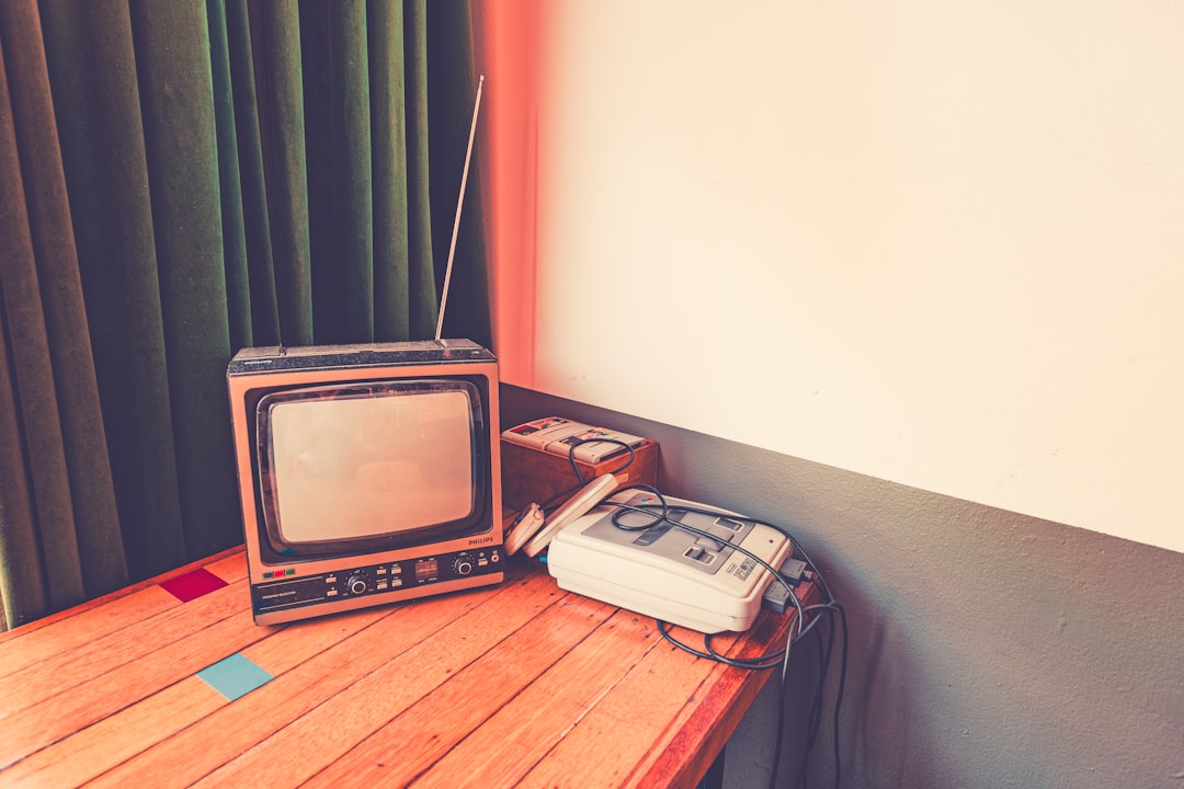 Vintage television and radio on a wooden table.