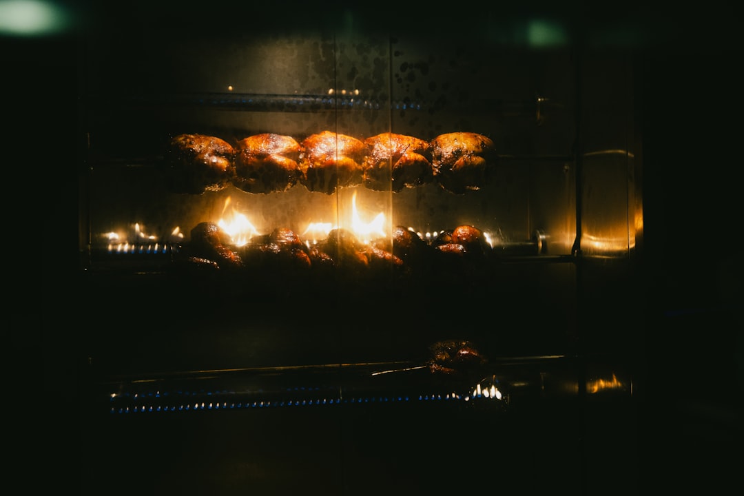 Chickens rotating on a rotisserie over flames