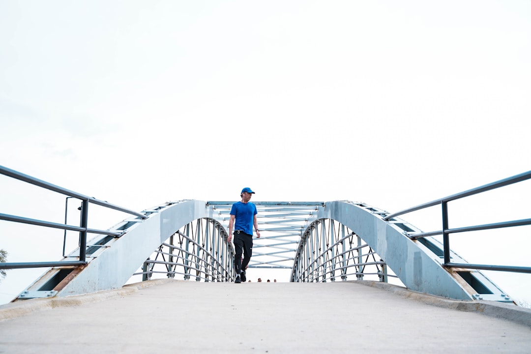 man wearing blue crew-neck t-shirt and black pants