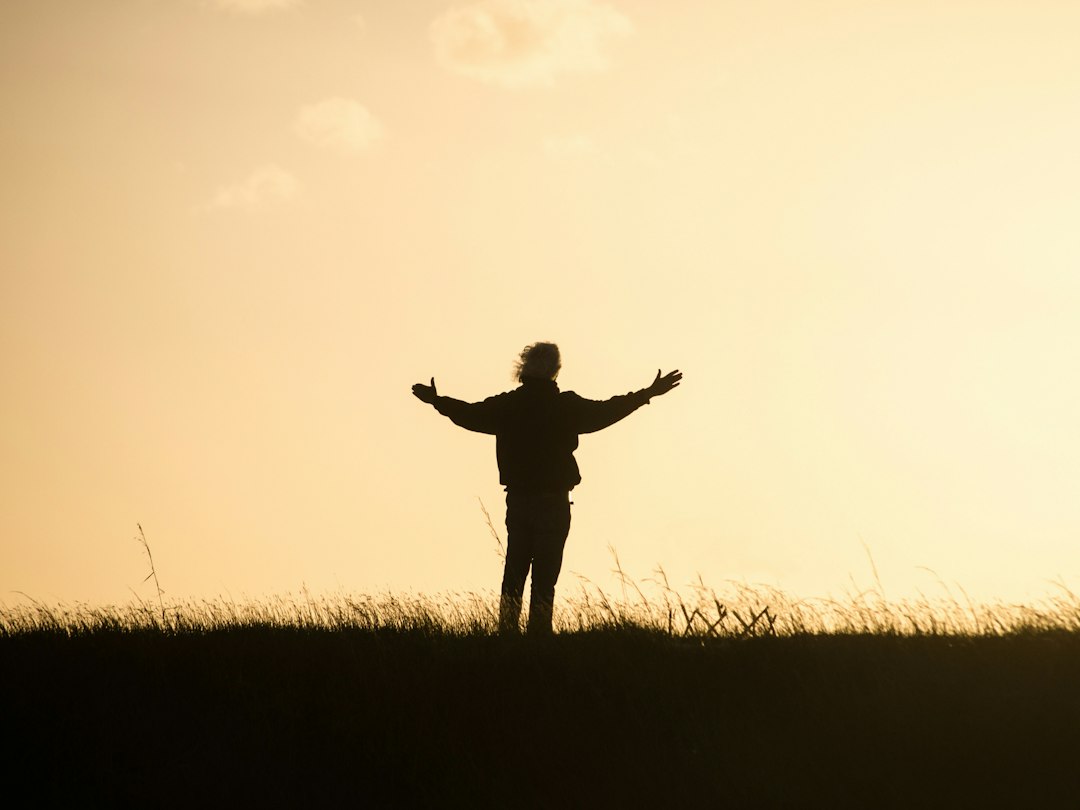 silhouette of person spreading hands