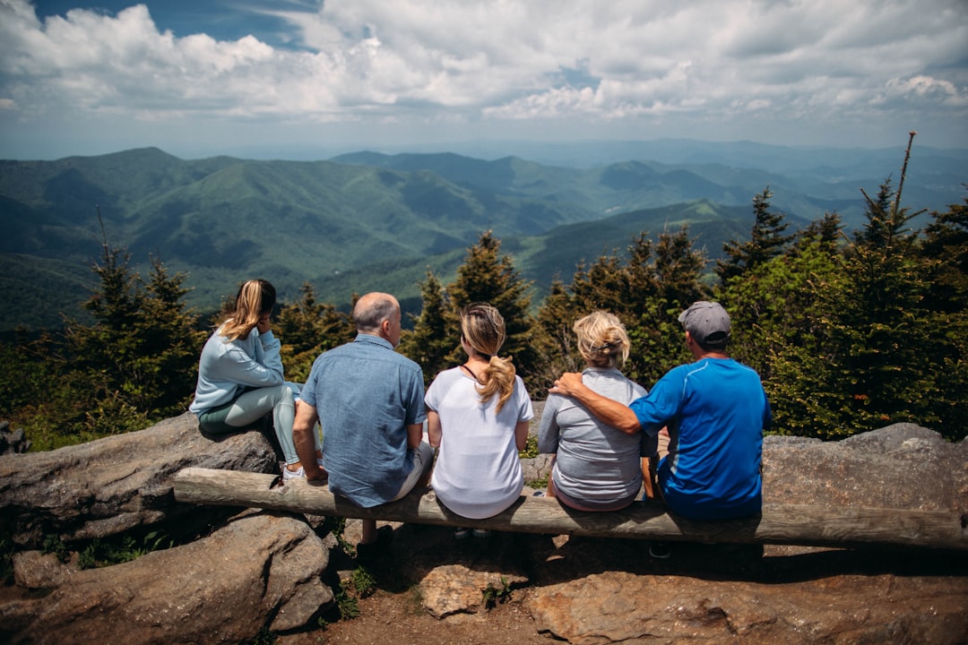 Group of people sitting on rocks overlooking mountain