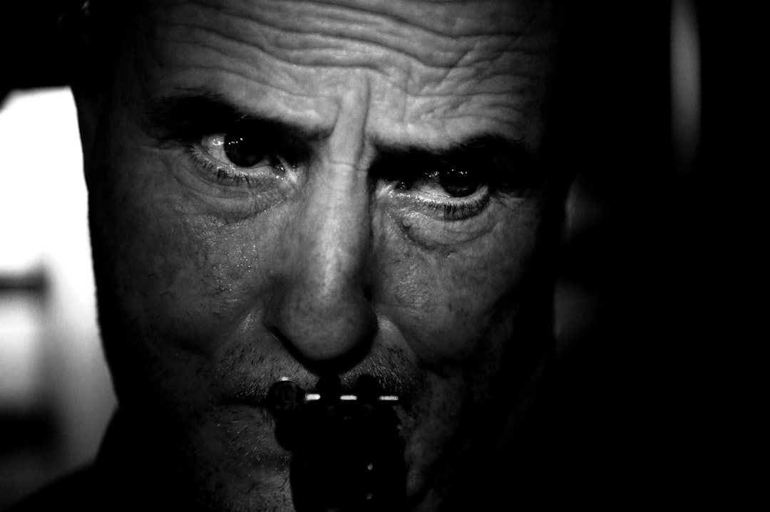 A man plays the harmonica in black and white