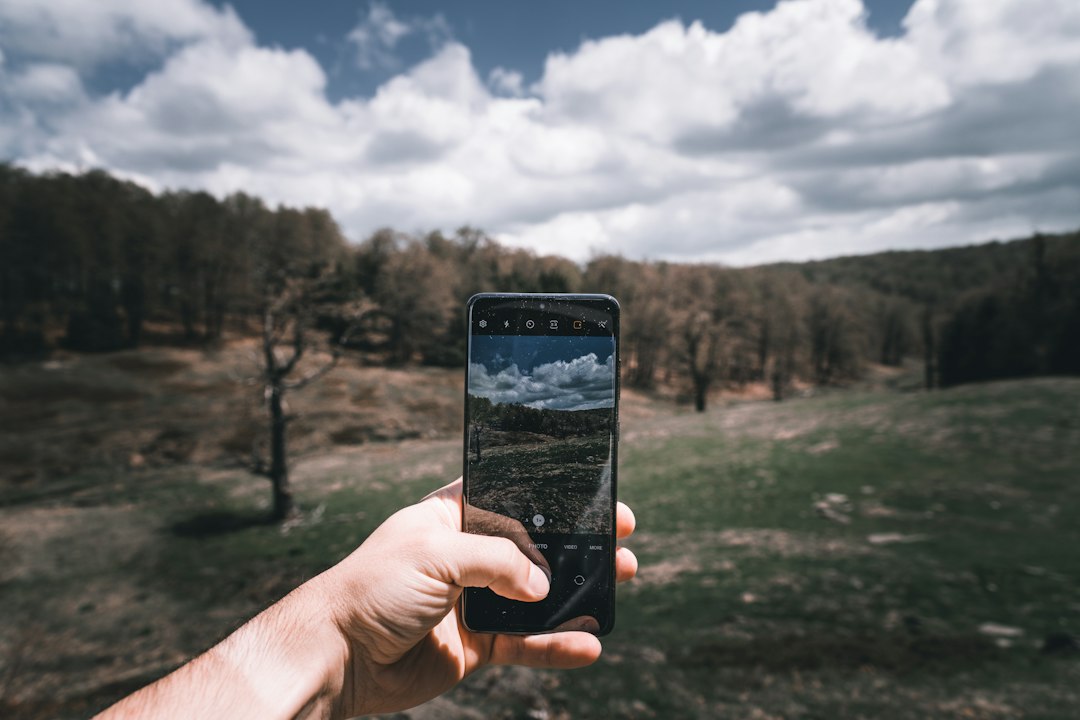 Hand holding a Samsung S20Ultra phone shooting a landscape.